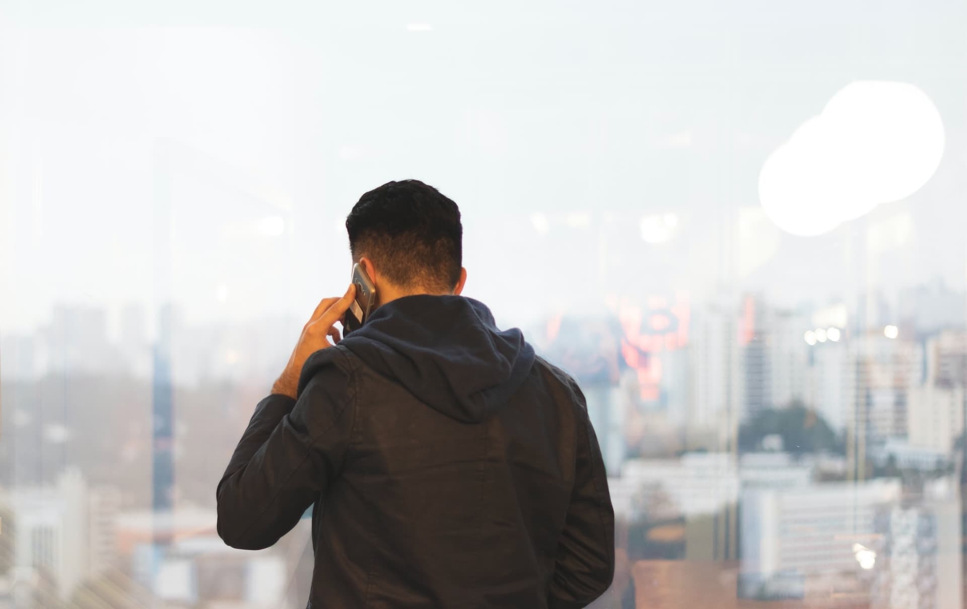 A backview of a man on high phone making a phone call